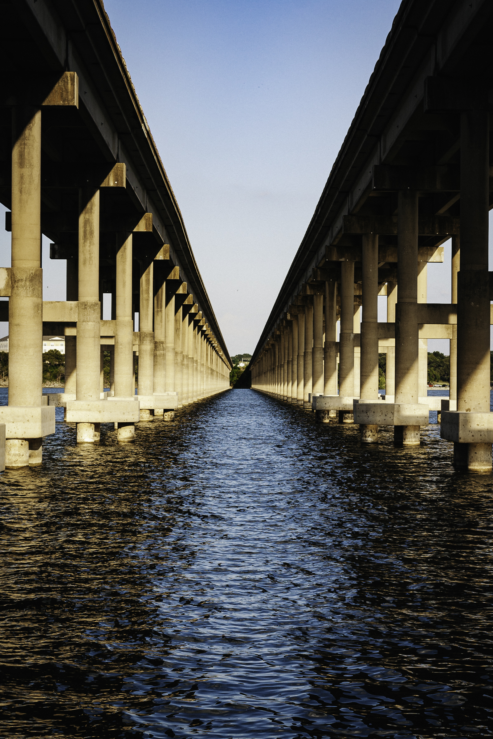 A symmetrical view between two bridges stretching toward the horizon