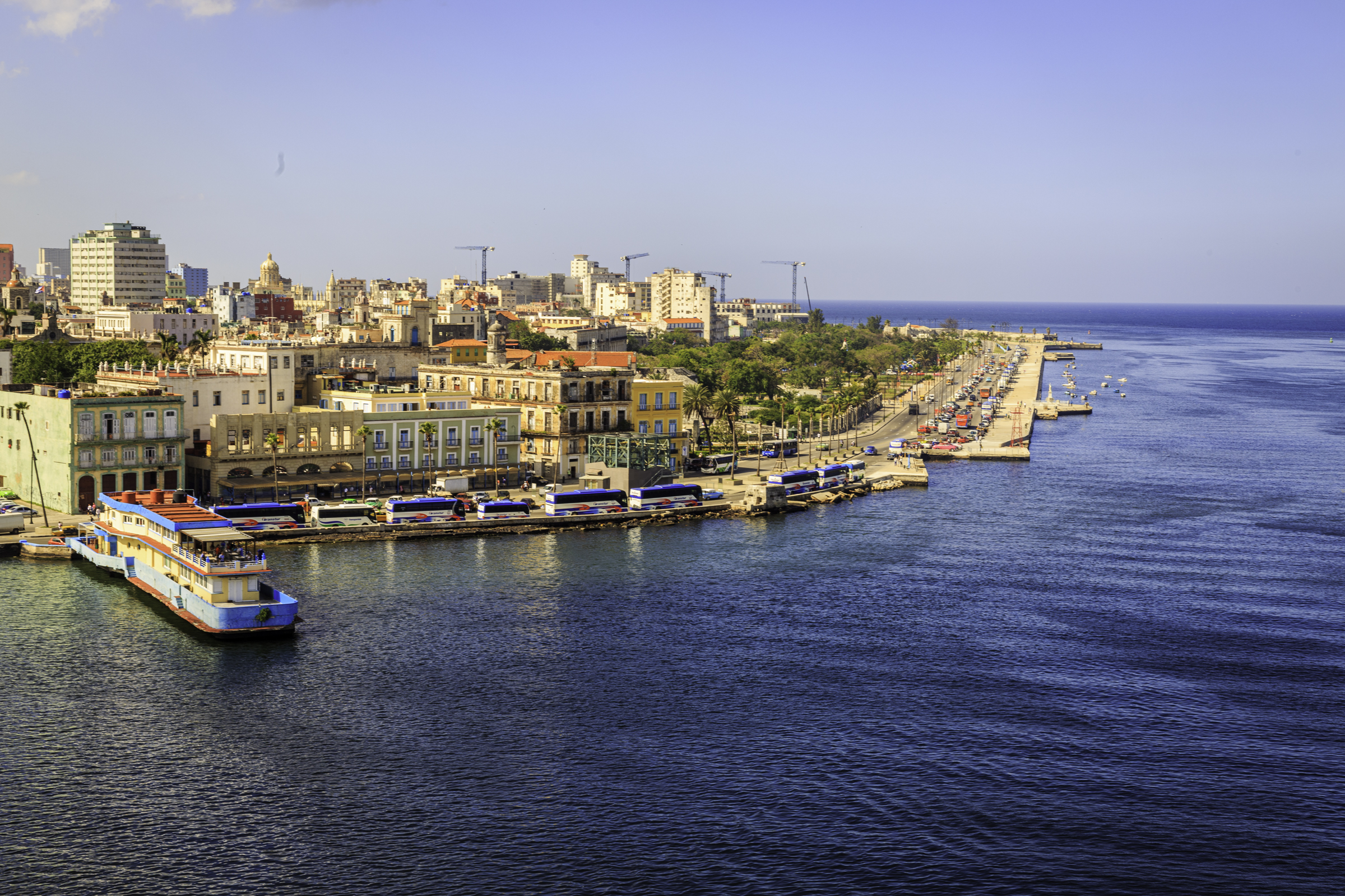 The colorful Havana waterfront with buses, cars, buildings, and the sea